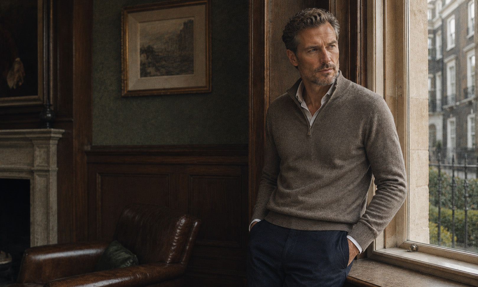 Man in a taupe quarter-zip sweater standing by a window in a wood-panelled room, shop Bernard Weatherill at Malford of London